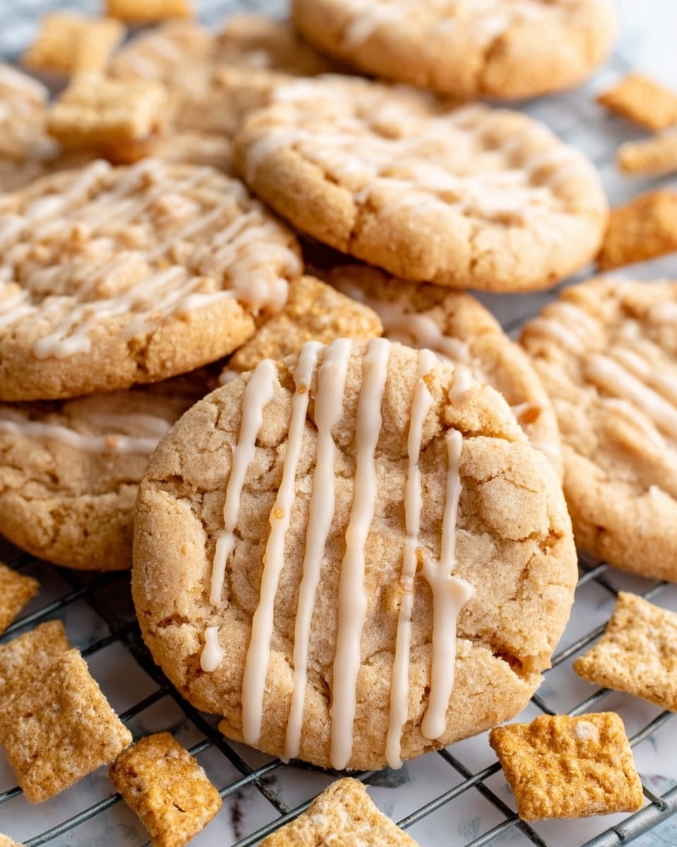 The image shows several golden brown cookies with a crisscross pattern on top, indicating they were pressed down before baking. These cookies have a slightly rough texture with tiny bits visible on the surface. A light drizzle of white icing is spread over each cookie, creating thin, shiny lines that highlight the crisscross design. The cookies are placed on a white marbled surface with some small square pieces of baked dough scattered around. Photo taken with an iphone --ar 4:5 --v 7
