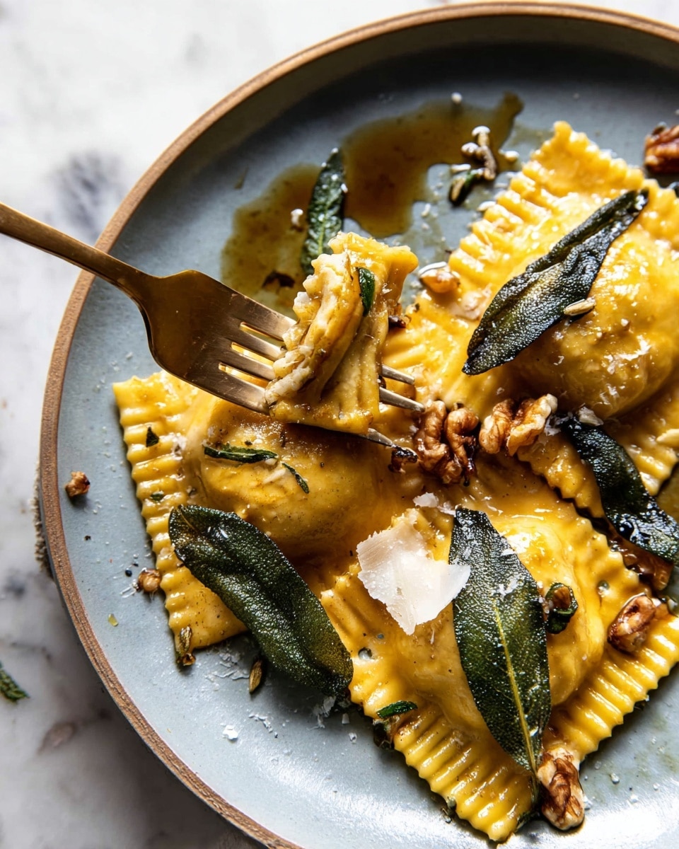 The image shows a close-up of three golden-brown ravioli pieces on a white plate, each with a square shape and crimped edges. The ravioli are covered in a glossy brown butter sauce, topped with crispy sage leaves and small walnut pieces. Some thin, curly shavings of pale cheese are scattered over the pasta. A gold fork is placed on the plate, holding a piece of ravioli. The background is a white marbled texture. photo taken with an iphone --ar 4:5 --v 7