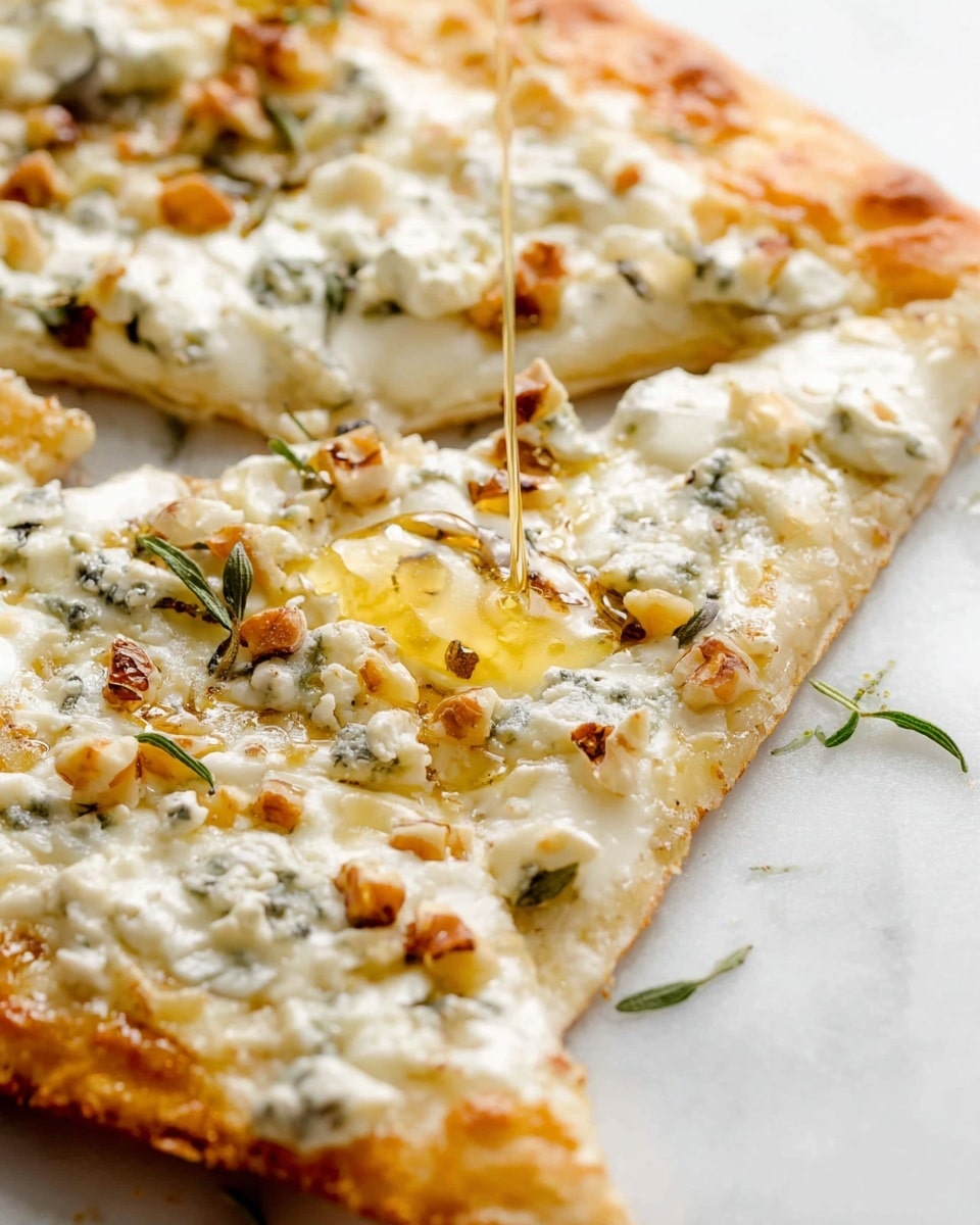 A close-up view of a flat rectangular pizza on a white marbled surface, showing a golden-brown crust with a thin, crispy texture as the base layer. The second layer is melted white cheese spread unevenly across the surface, topped with small chunks of blue cheese that have a creamy texture and blue-green veins. Scattered on top are small pieces of chopped nuts in light brown, adding texture and color contrast. A thin stream of honey is being poured over the pizza, creating a glossy, sticky layer with a golden yellow shine that drips down the edges. The overall look highlights the mix of creamy, crunchy, and sweet elements on the pizza. photo taken with an iphone --ar 4:5 --v 7