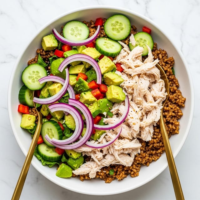 A white bowl filled with a colorful salad is placed on a white marbled surface. The base layer consists of brown rice cooked with seasoning, giving a textured, slightly crispy look. Scattered on top are bright green cucumber slices and chunks of green avocado, adding freshness. Thin slices of red onion curve across the salad, creating a striking contrast with the green and brown layers. Small pieces of red bell pepper are mixed throughout, adding pops of red color. Flaked white chicken is spread evenly over the salad, completing the mix of textures and colors. Two gold spoons rest inside the bowl, ready for serving. Photo taken with an iphone --ar 4:5 --v 7