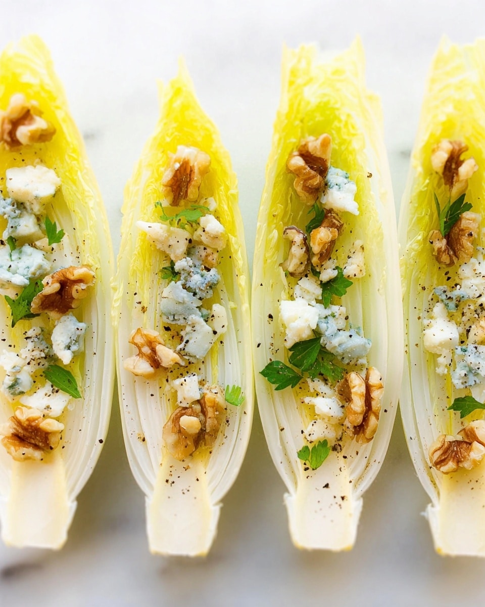 Five pale yellow endive leaves are arranged in a row on a white marbled surface, each leaf filled with similar layers: small green parsley leaves, crumbled blue cheese with white and blue tones, and light brown chunky walnut pieces. The textures vary from smooth and slightly crinkled in the endive, crumbly in the cheese, and rough in the walnuts. Each bite-sized endive boat has a fresh and natural look, with tiny black pepper specks scattered over the fillings, adding a subtle contrast. The image is softly lit and taken close-up, showing the details of the ingredients clearly. photo taken with an iphone --ar 4:5 --v 7